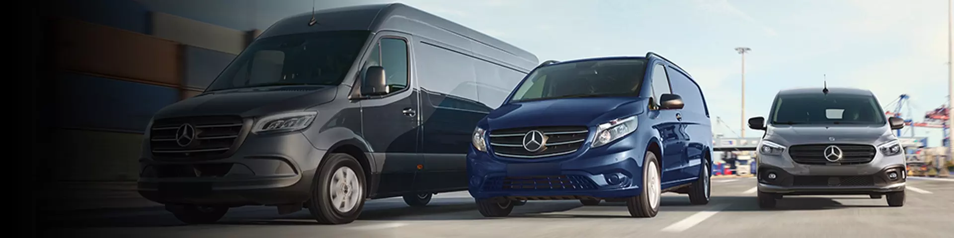 Large, medium and small Mercedes vans driving on a highway.